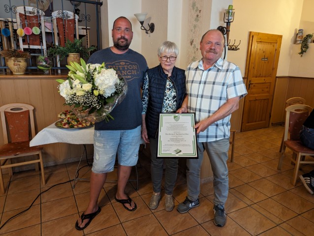 Marco Rostalski (links) und Frank Bunke bedankten sich bei Waltraud Tschierschke im Namen des Vereins herzlich für ihre unermüdliche Arbeit und überreichten ihr einen großen Blumenstrauß und die Urkunde der Ehrenmitgliedschaft.